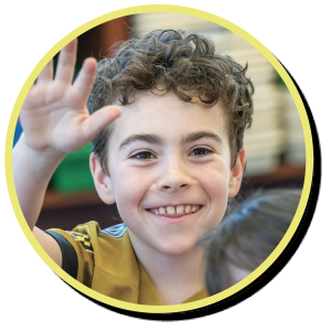 portrait of boy smiling with hand in air